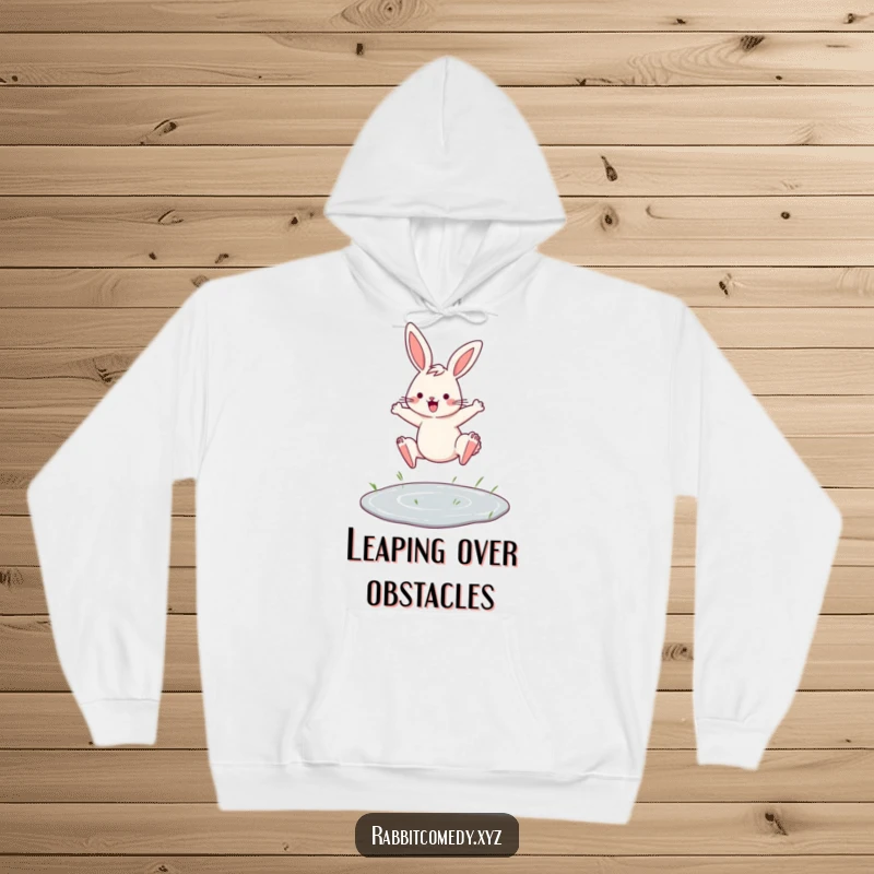 Funny hoodie featuring a determined rabbit leaping over a tiny puddle with flair, offering warmth and motivational vibes.